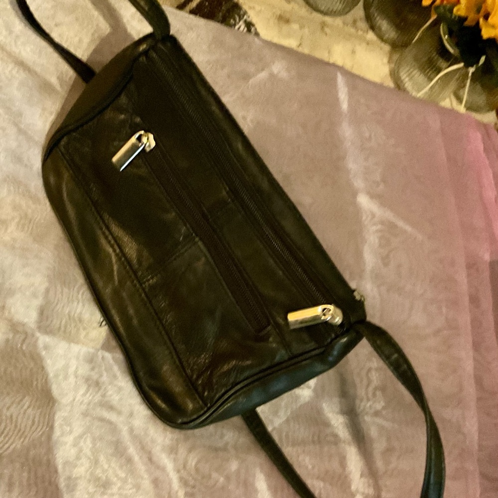 Women’s hand bag with shoulder strap. Black, with multiple compartments.